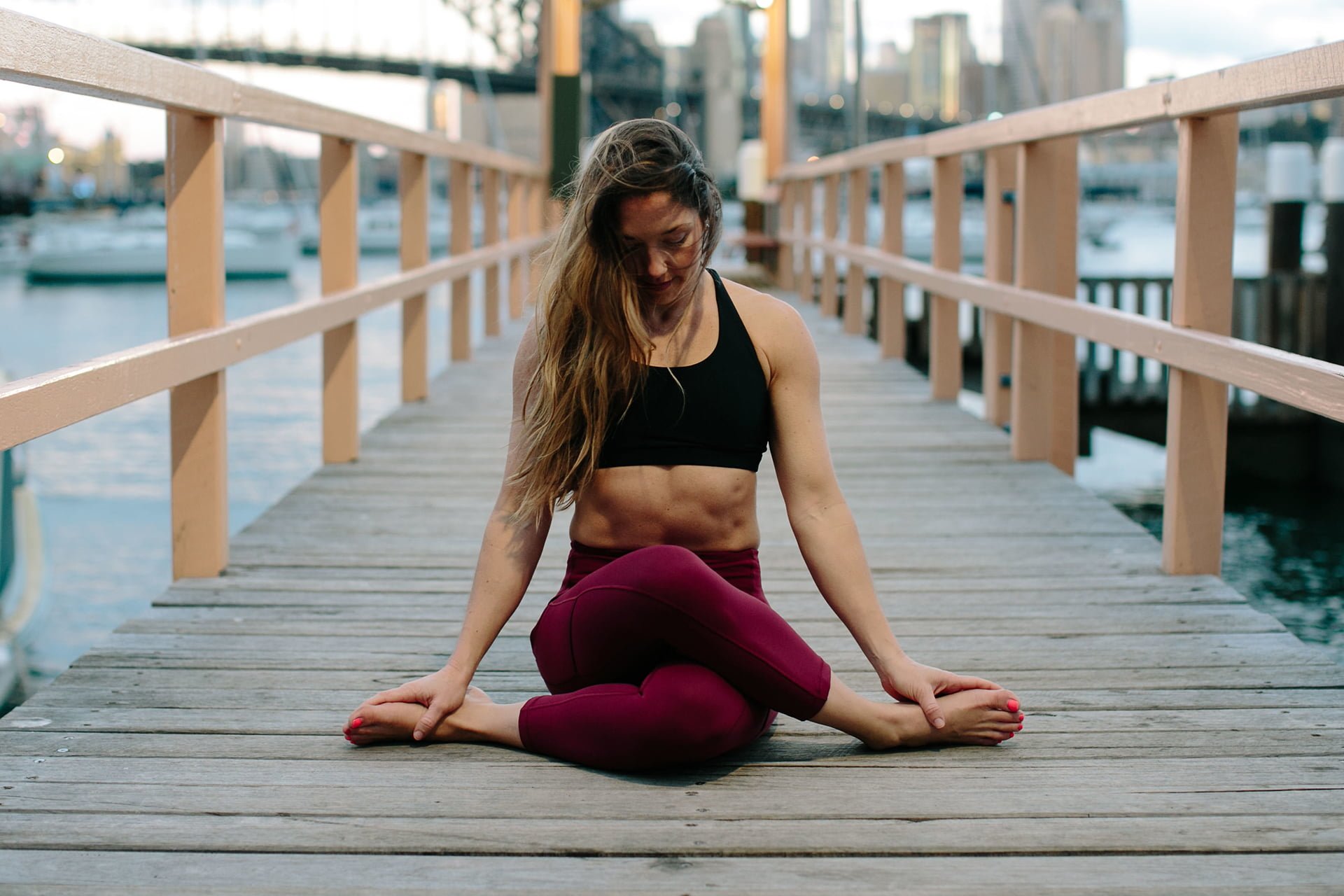 Kat Clayton in meditation seated yoga pose in red pants