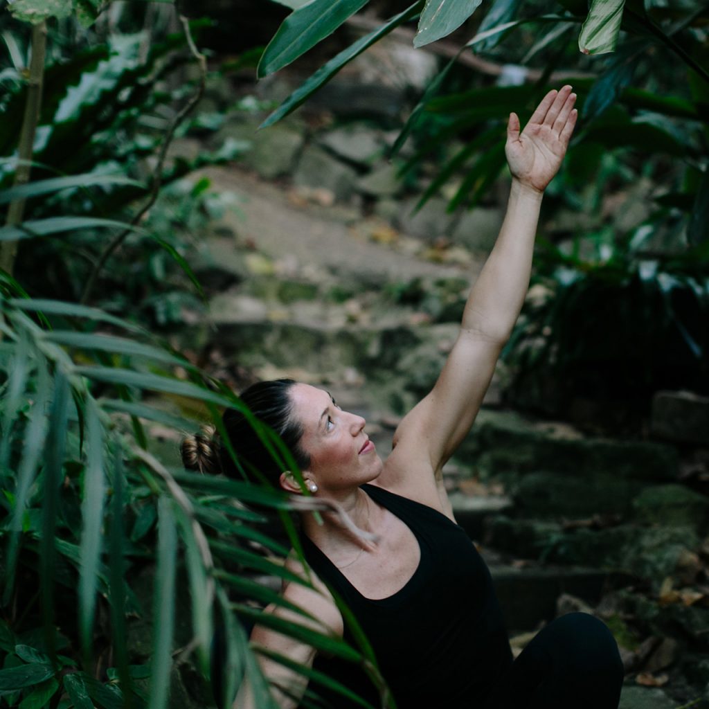 Girl doing yoga in Nature with palm trees